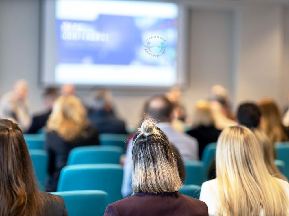 Public attentif assis dans une salle lors d'une conférence d'Harmonie Apprentissage sur les troubles du neurodéveloppement.