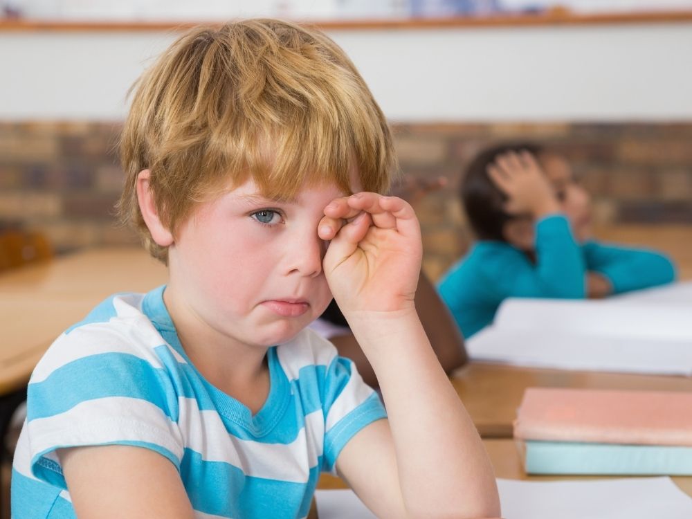 Jeune garçon hypersensible en classe montrant des signes de fatigue émotionnelle, accompagné par Laurélia Steinmetz pour mieux gérer sa scolarité à Thionville.