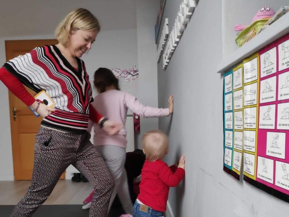 Laurélia Steinmetz et des enfants qui réalisent des exercices ludiques de mouvement au mur pendant une séance de groupe.