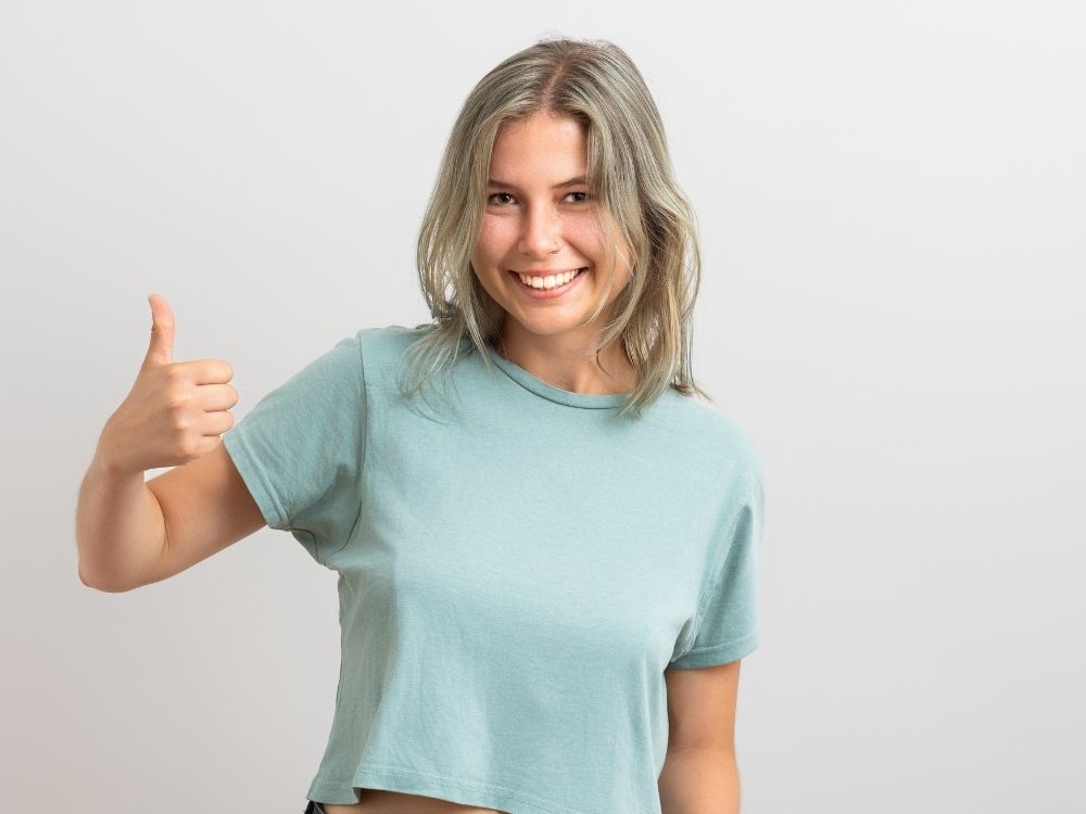 Femme souriante faisant un pouce vers le haut pour illustrer la réussite d'un suivi adultes
