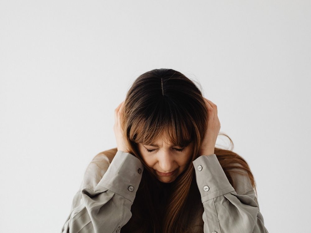 Femme se couvrant les oreilles avec les mains pour se protéger du bruit